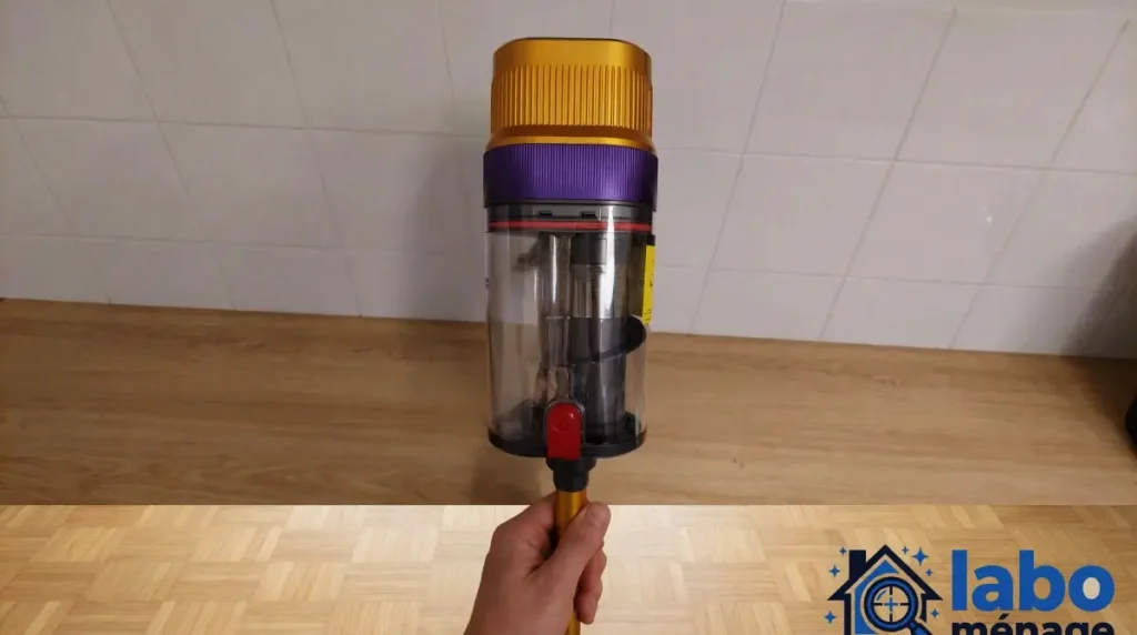 Corps principal tenu verticalement à la main, avec réservoir transparent visible.